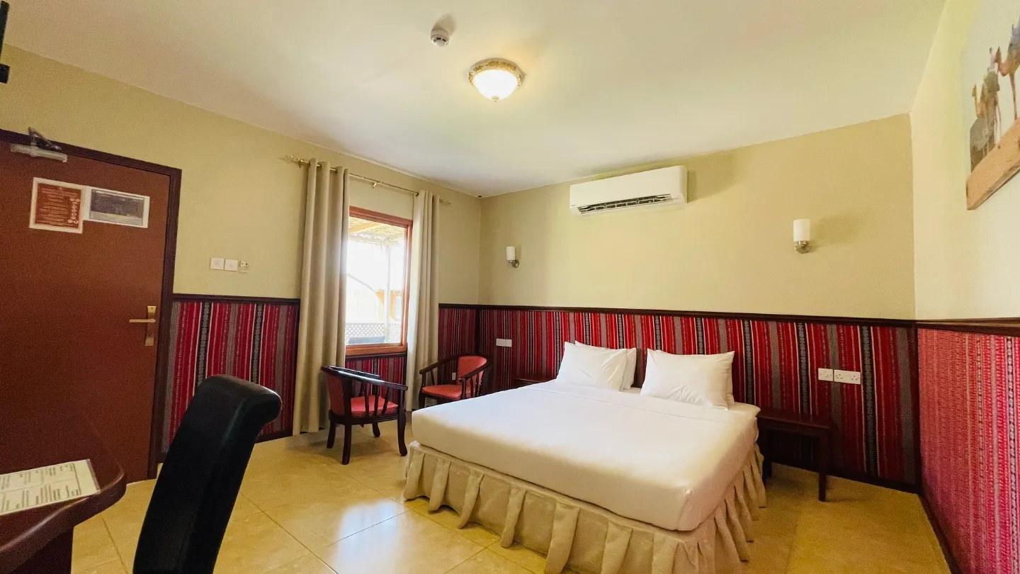 Hotelzimmer mit Bett und Stühlen